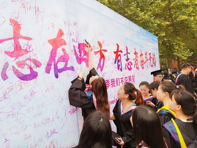 图18 毕业生在签名墙前签名