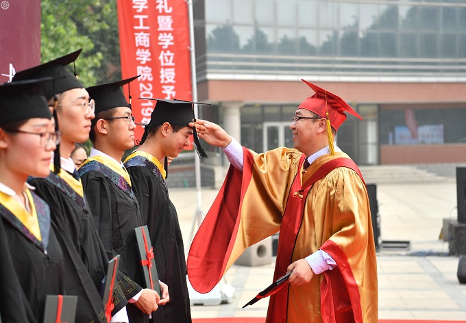 图3:孟庆瑜为2019届毕业生代表颁发毕业证书和学位证书